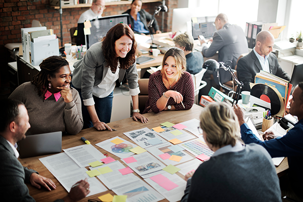 group of adult learners working at table covered with brightly colored paper